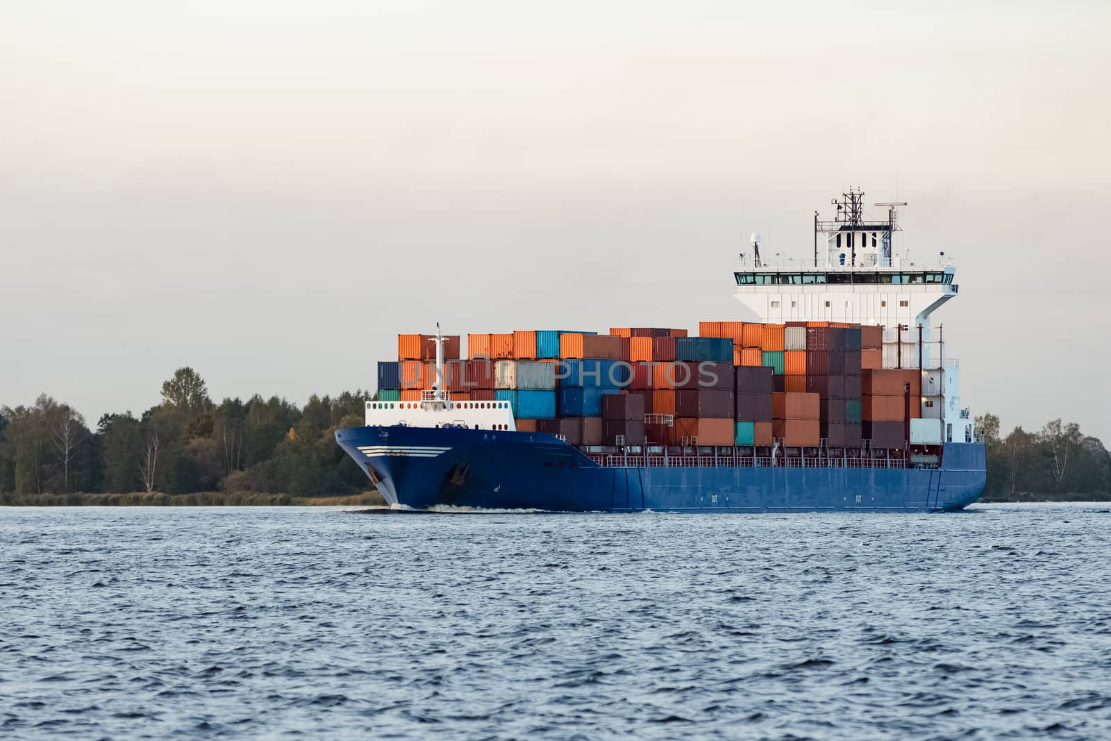 Blue container ship moving to Baltic sea. Riga, Latvia