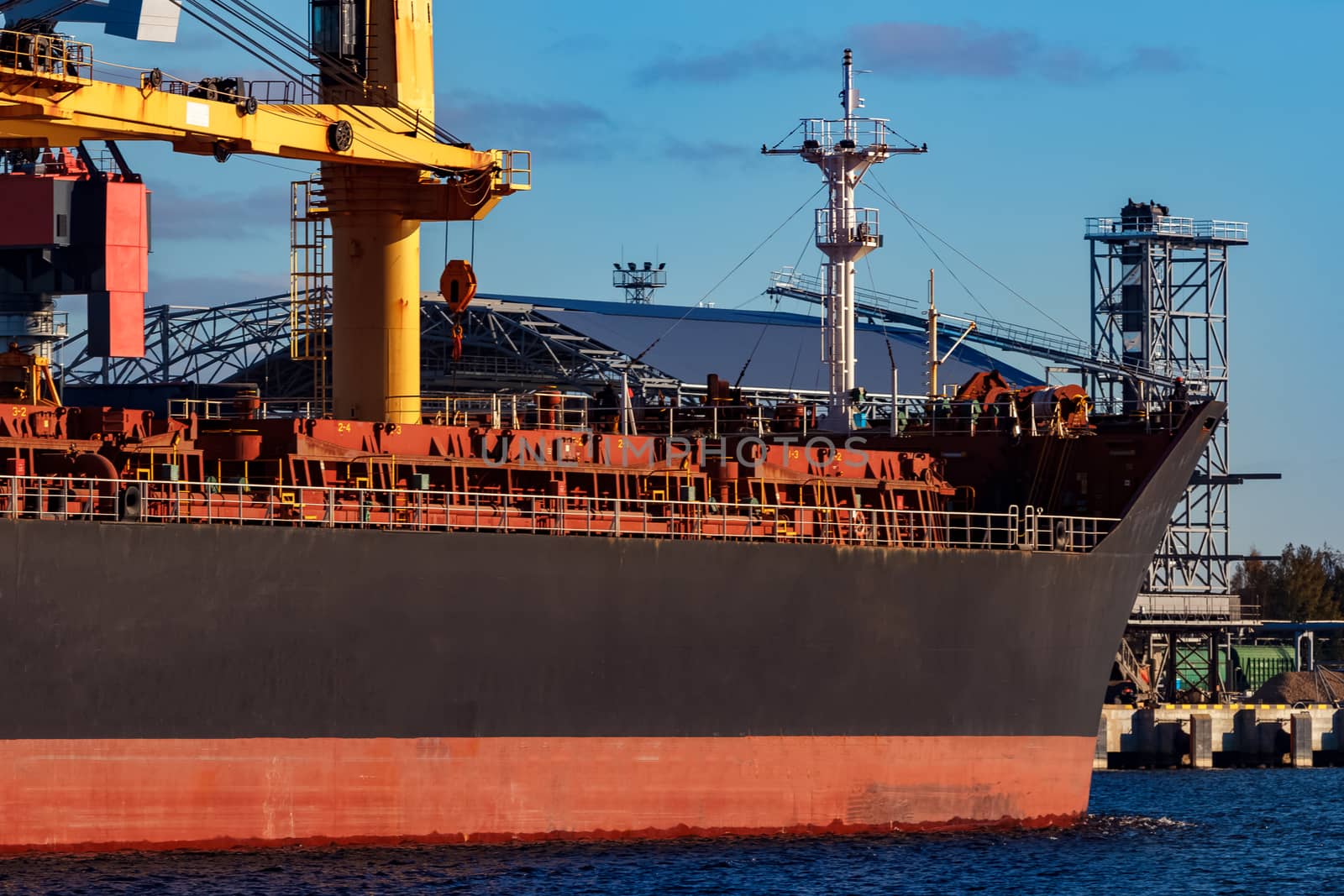 Black cargo ship entering the port of Riga, Europe