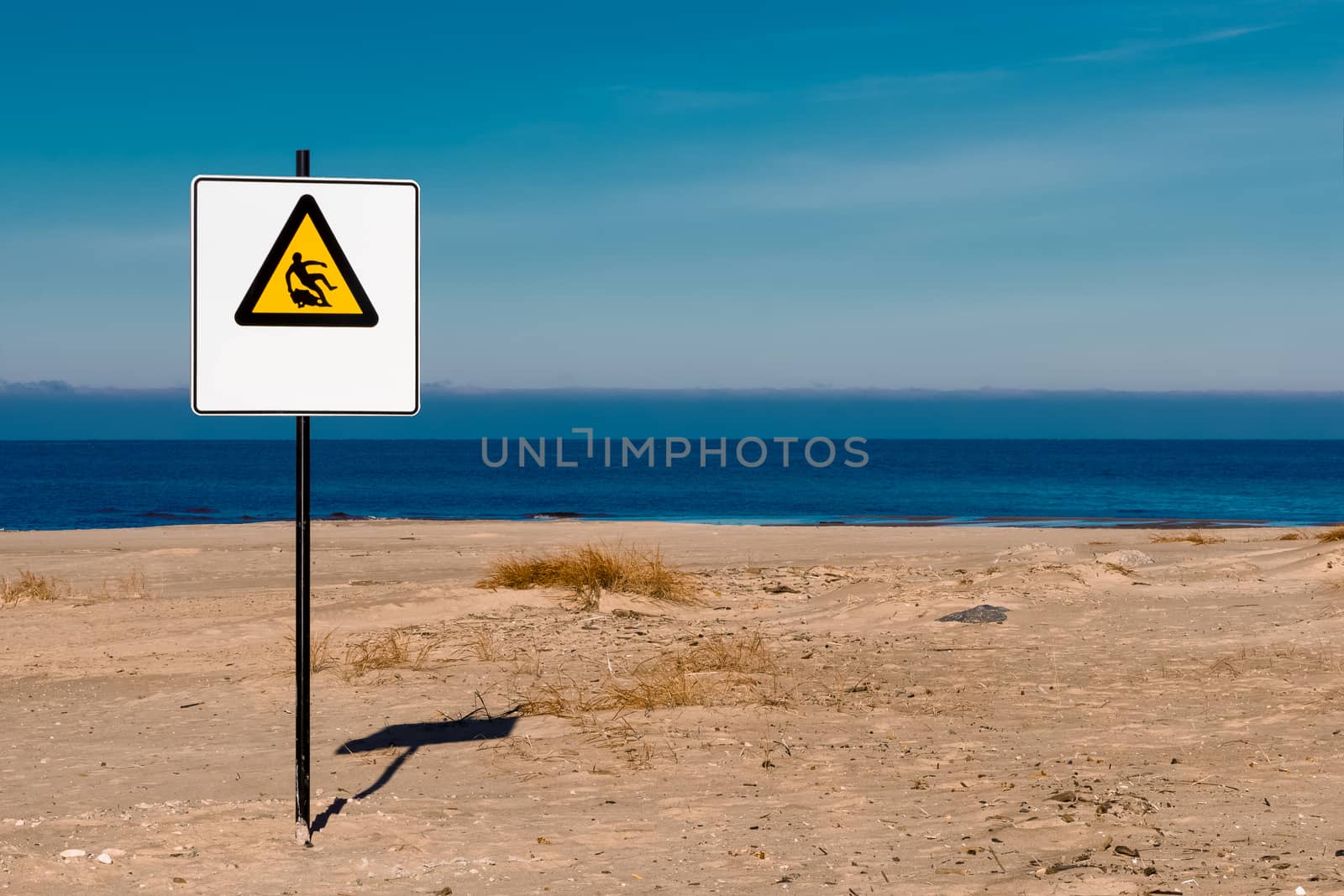 Yellow warning sign on summer beach, Riga