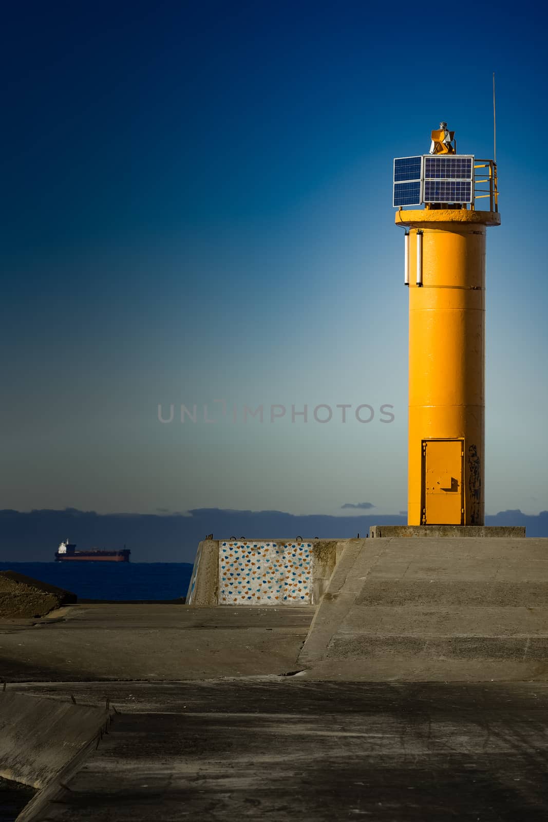 Yellow lighthouse on breakwater dam in Riga, Europe