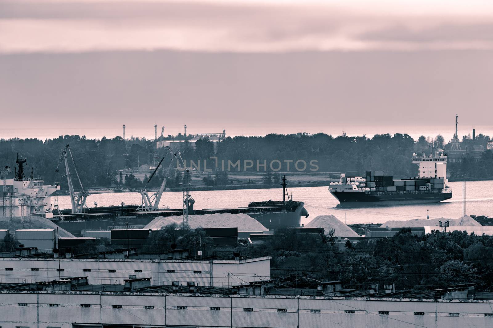 Red container ship entering port of Riga, Latvia