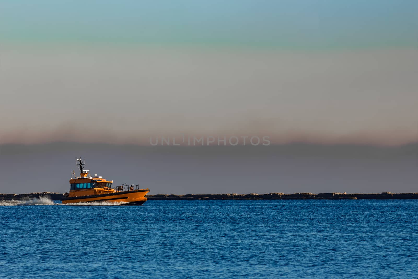 Orange pilot ship sailing from the Baltic sea in Latvia