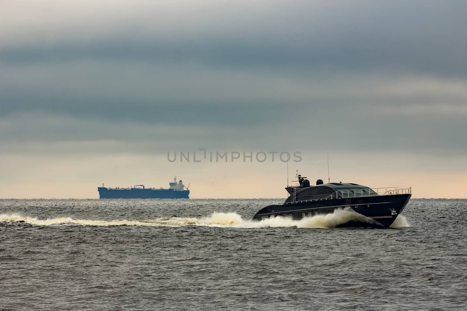 Black elite speed motor boat moving fast from Baltic sea