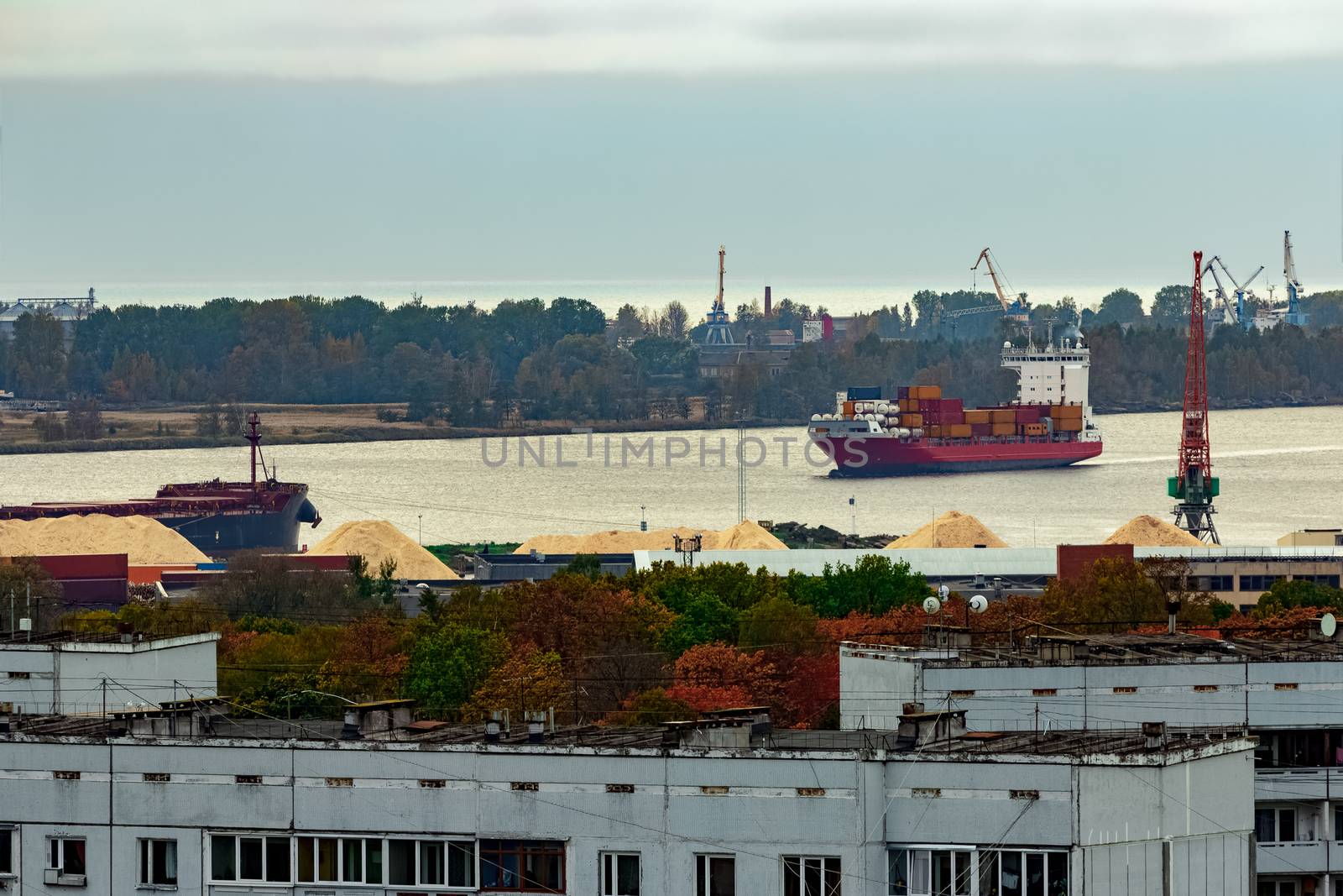 Red container ship entering port of Riga, Latvia