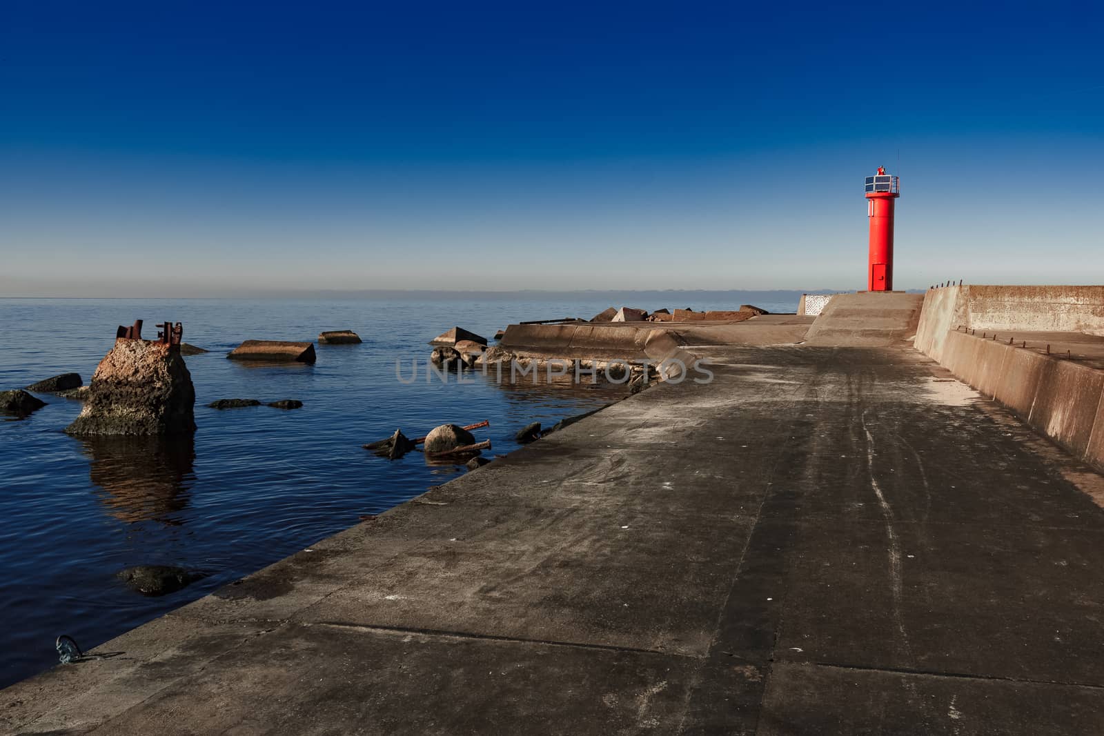 Red lighthouse on breakwater dam by sengnsp