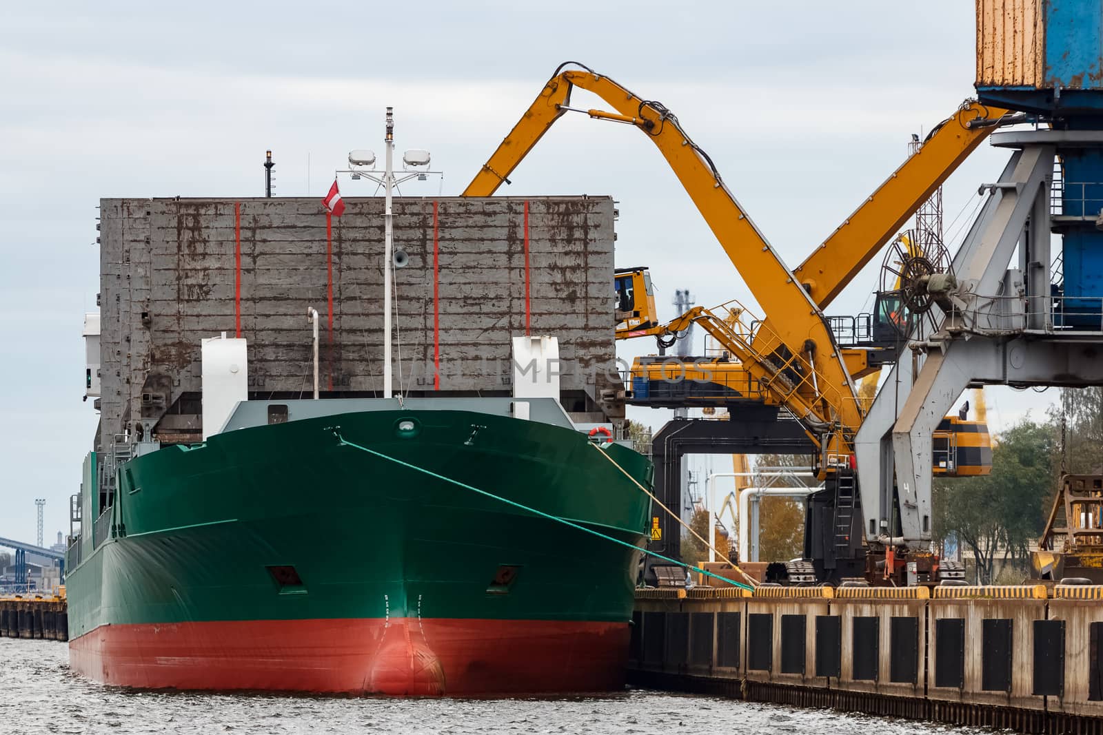 Green cargo ship loading in the port of Riga, Europe