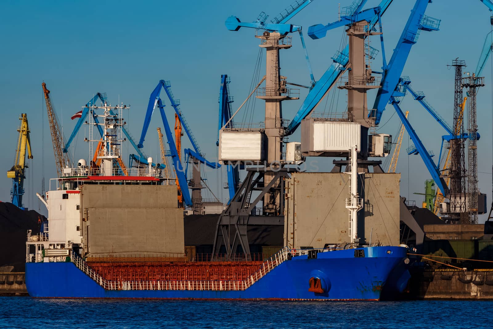 Blue cargo ship loading in the port of Riga, Europe