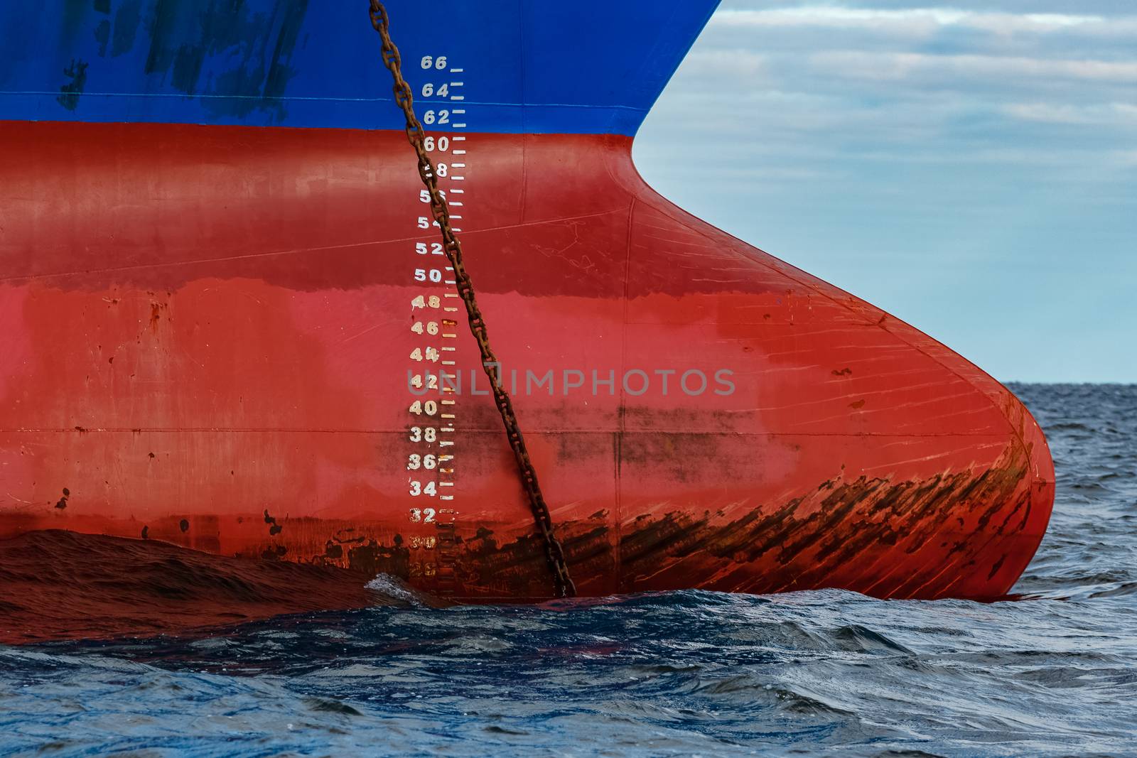 Blue cargo ship moored in still Baltic sea water