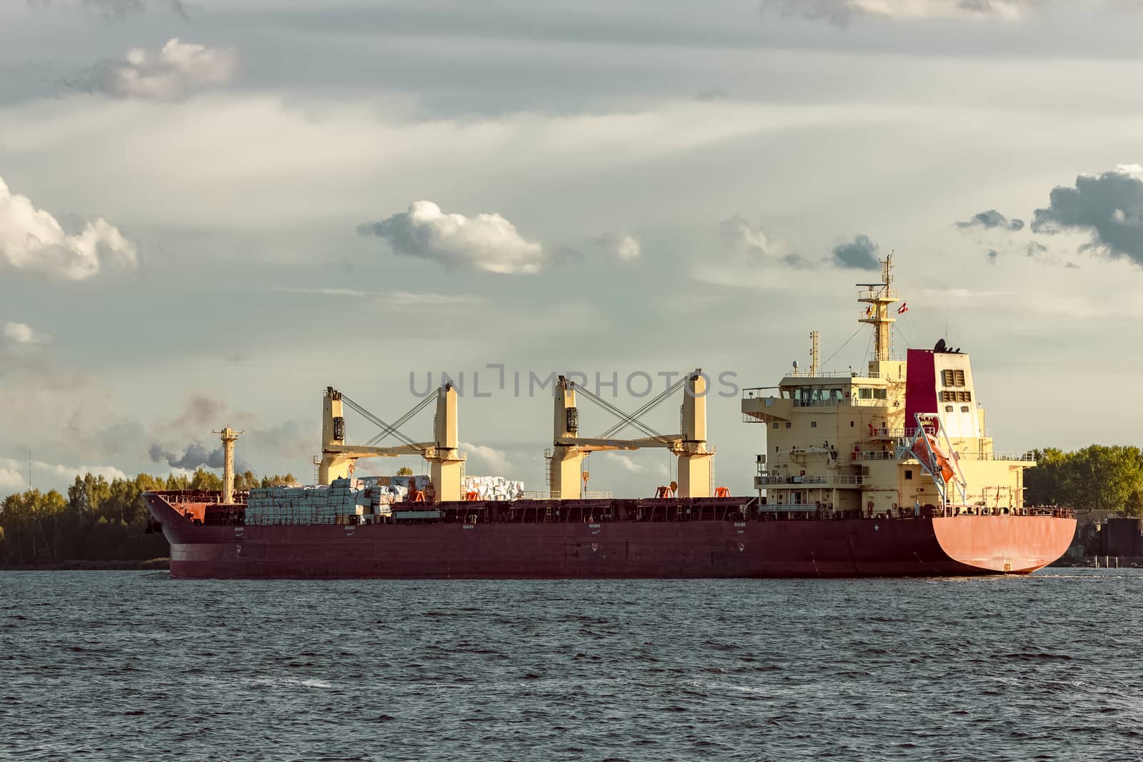 Red cargo ship sailing to the port of Riga