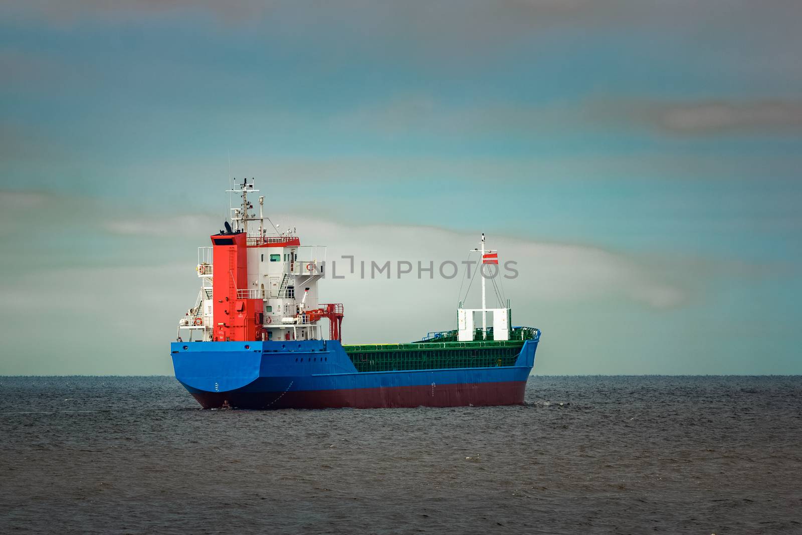 Blue cargo ship entering the Baltic sea. Riga, Europe