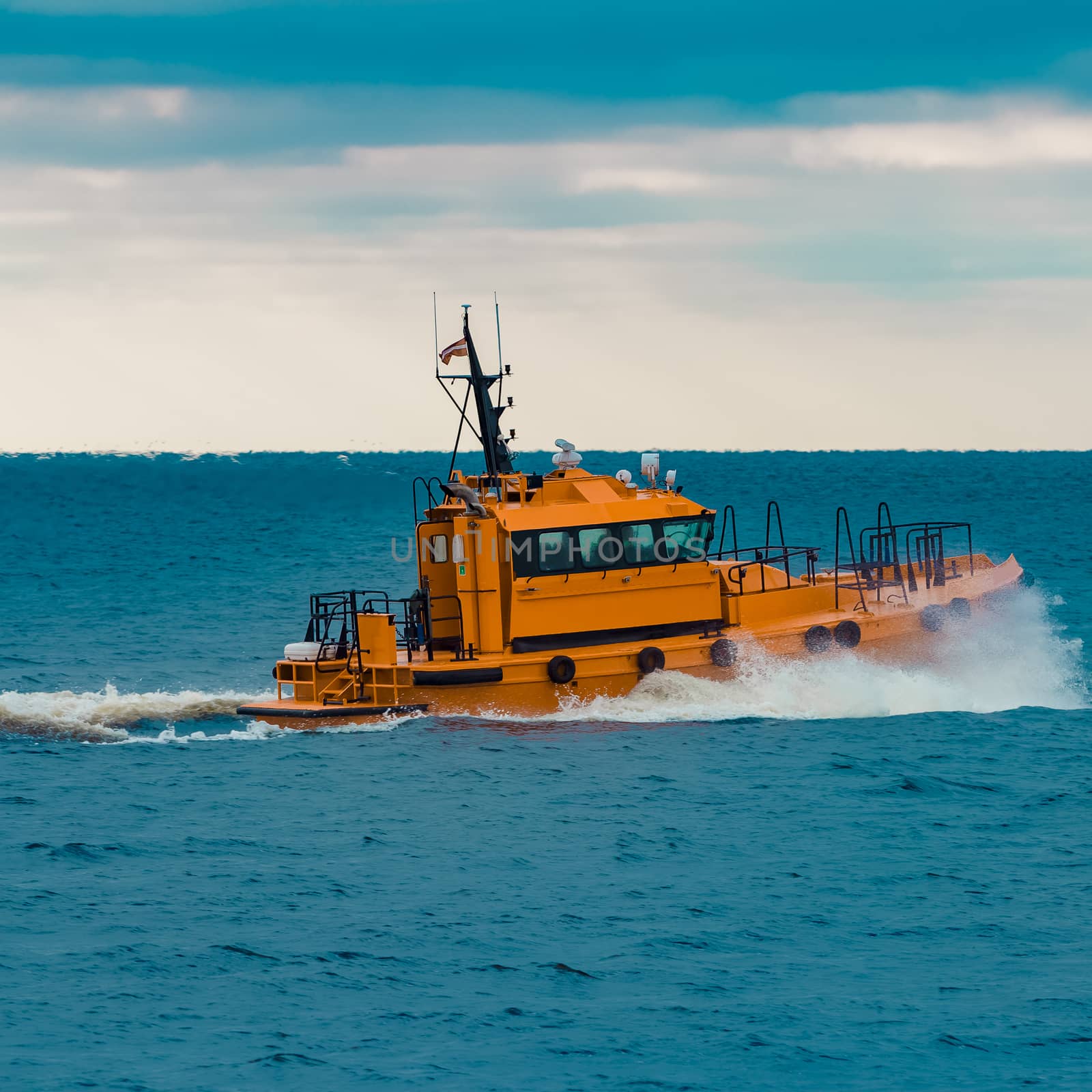 Orange pilot ship moving fast in Baltic sea. Europe