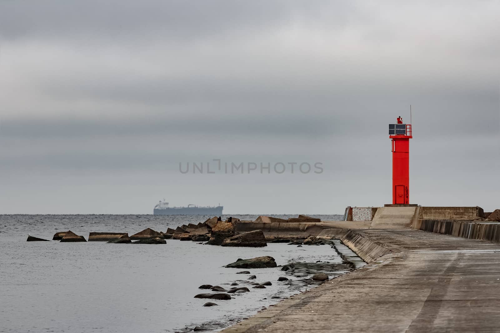 Breakwater dam with red lighthouse by sengnsp