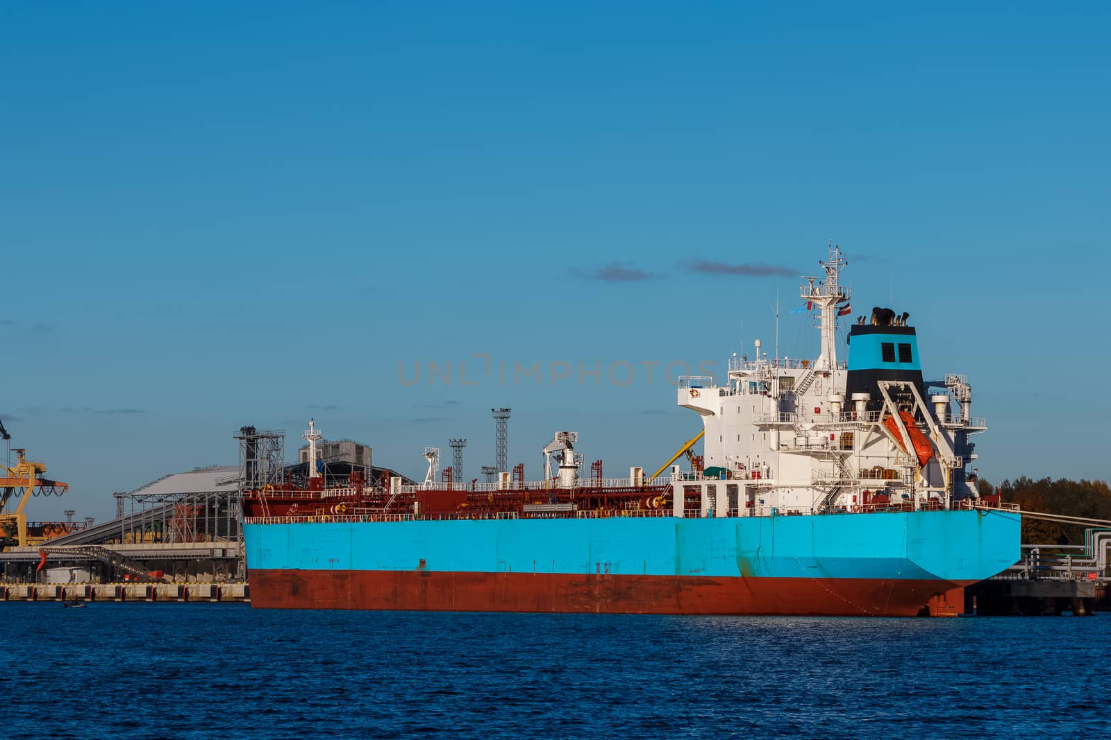 Blue cargo ship loading in the port of Riga, Europe