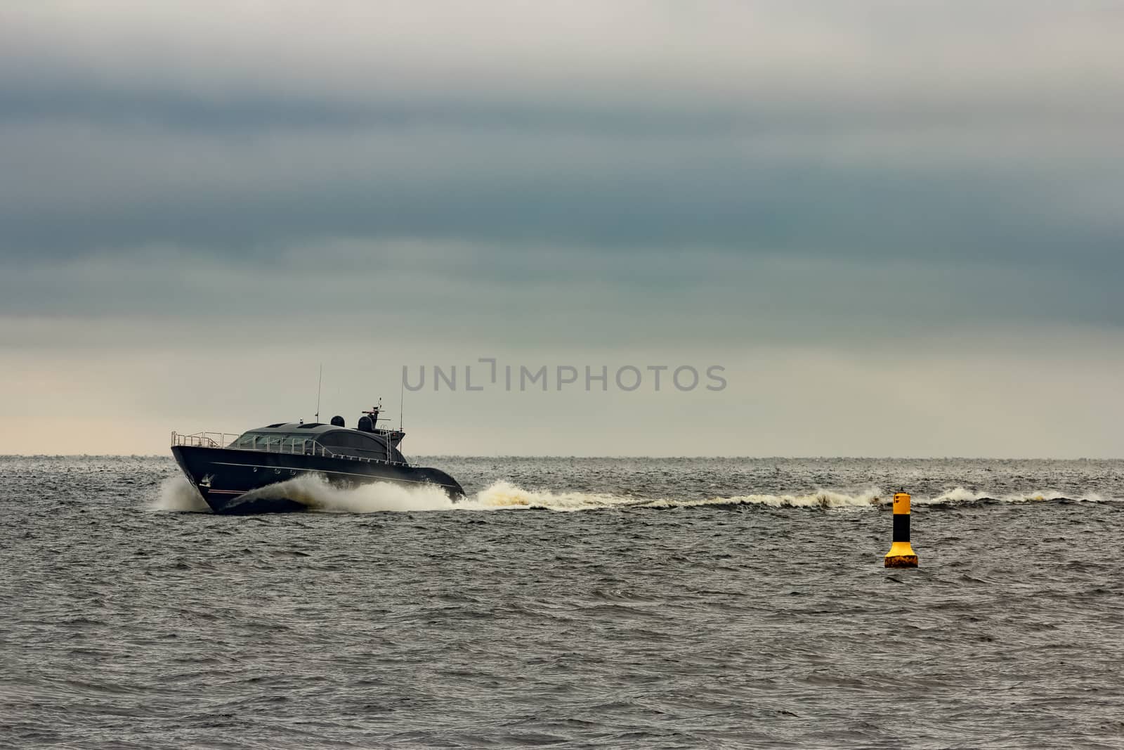 Black elite speed motor boat moving fast from Baltic sea