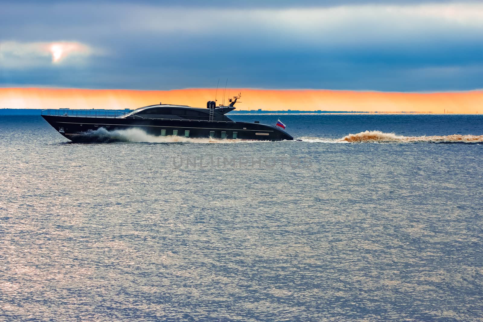 Black elite speed motor boat moving fast from Baltic sea