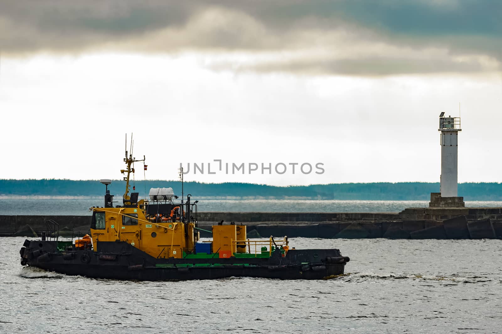 Small orange tug ship moving from the Baltic sea