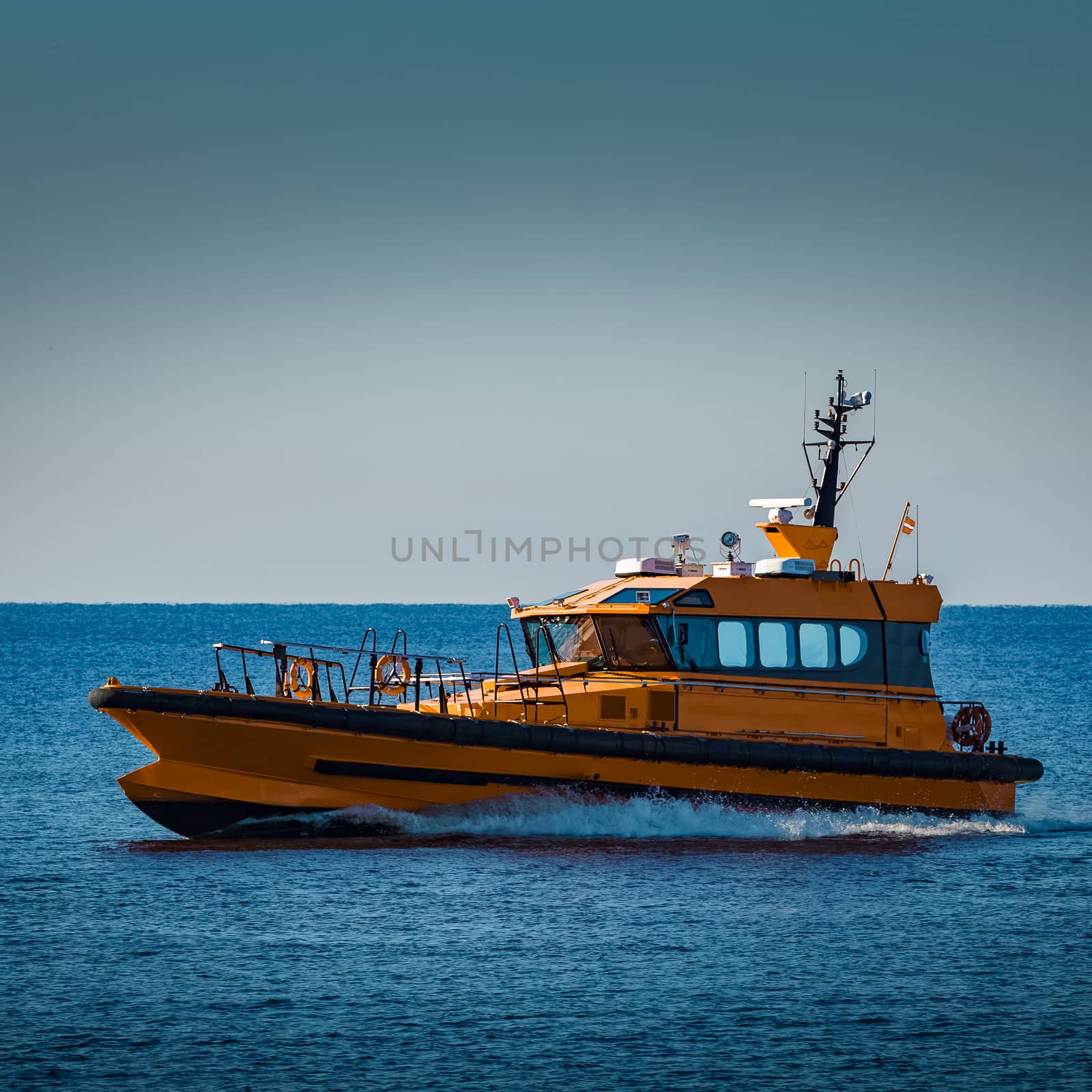 Yellow pilot ship moving at speed from the Baltic sea