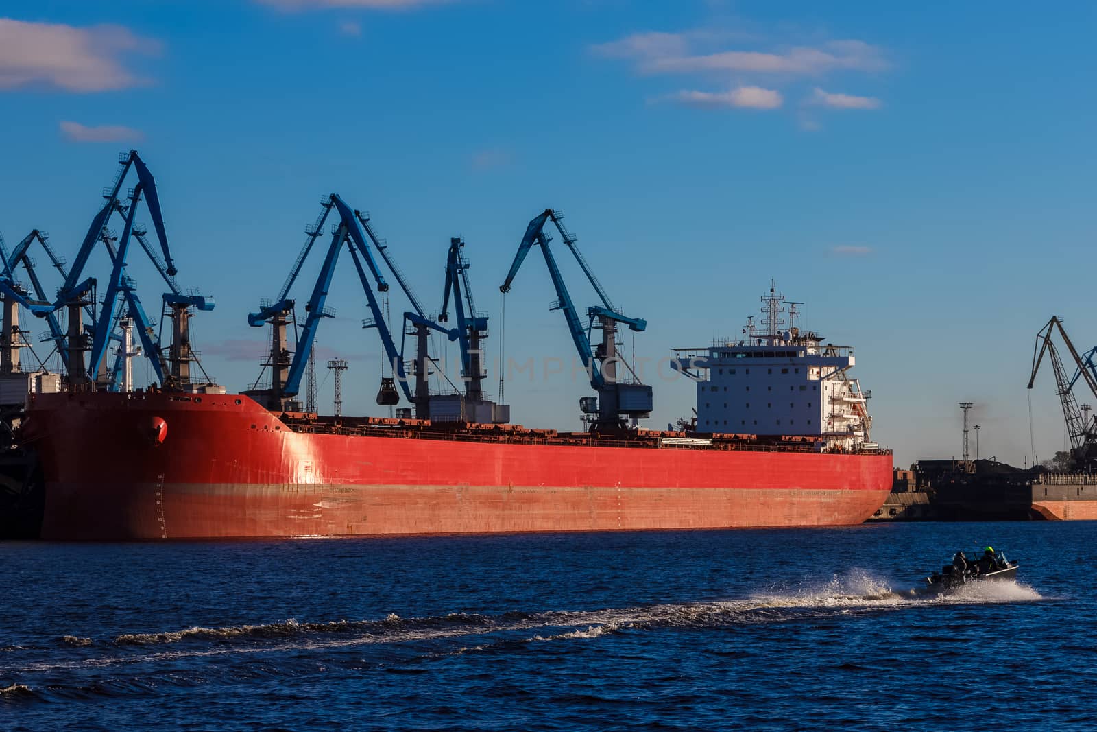 Red cargo ship loading in the port of Riga, Europe