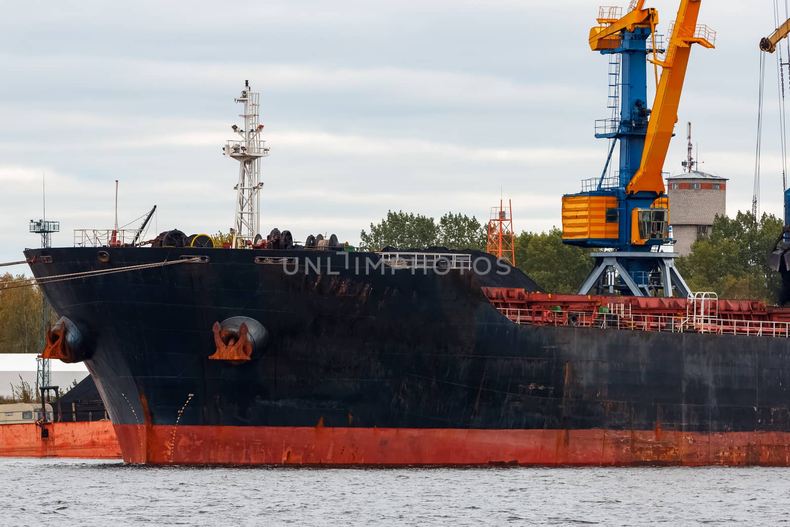 Black cargo ship loading in the port of Riga, Europe