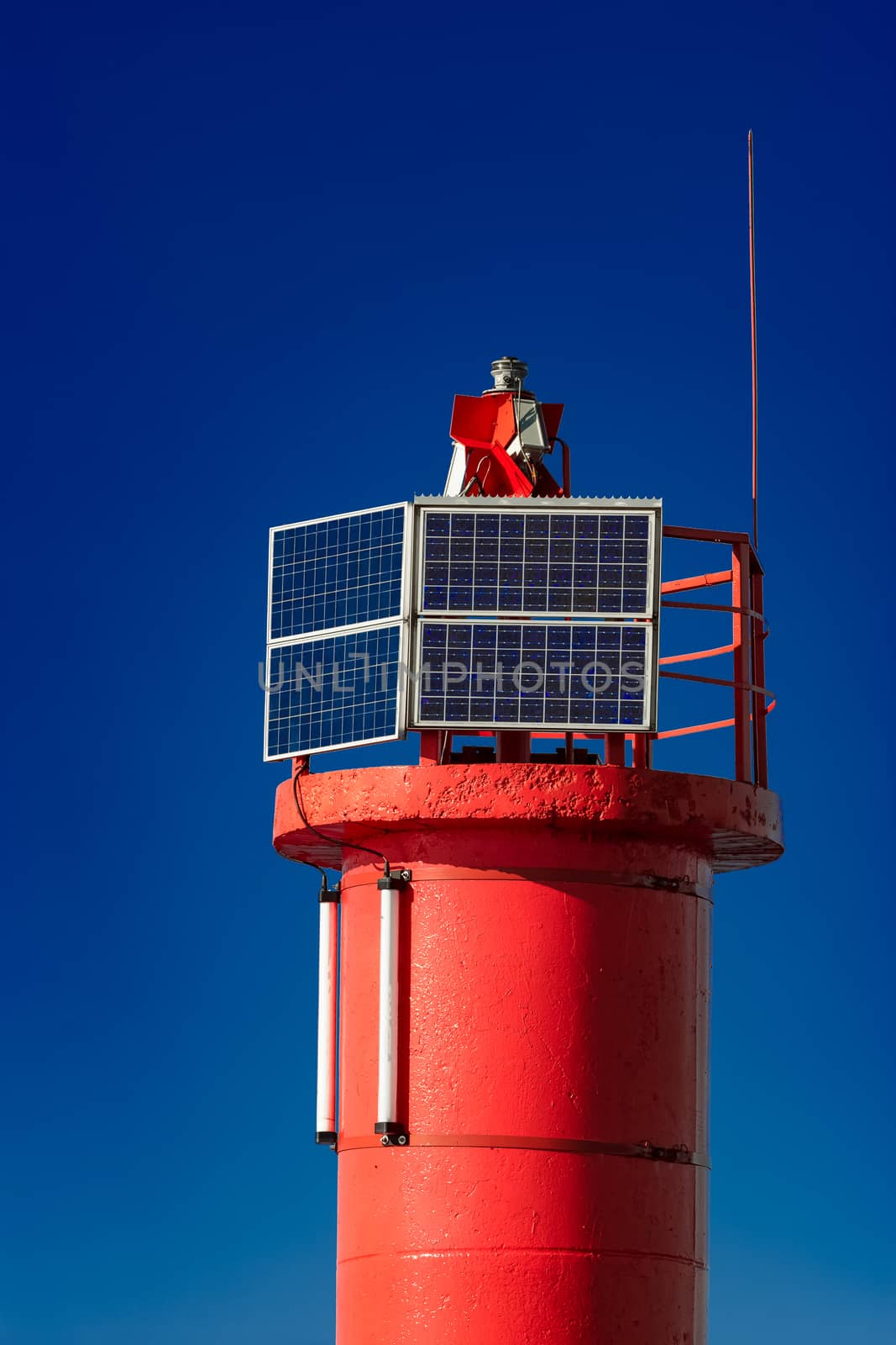 Red lighthouse against blue sky by sengnsp