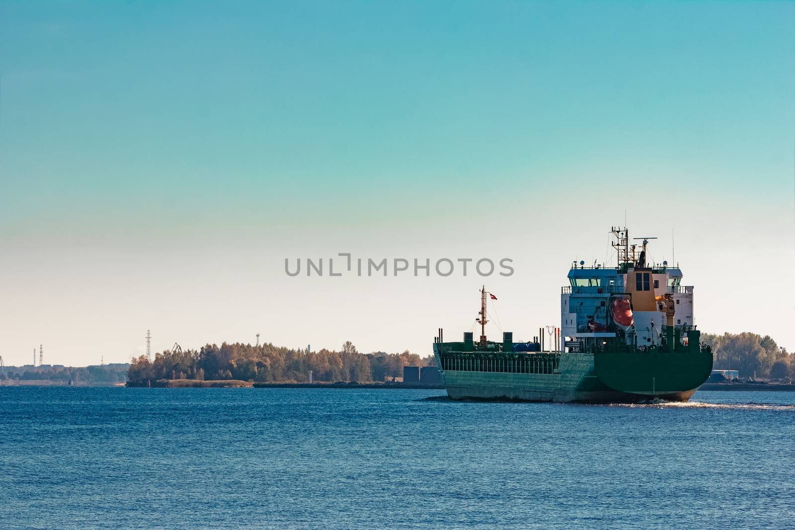 Green cargo ship entering a port of Riga, Europe