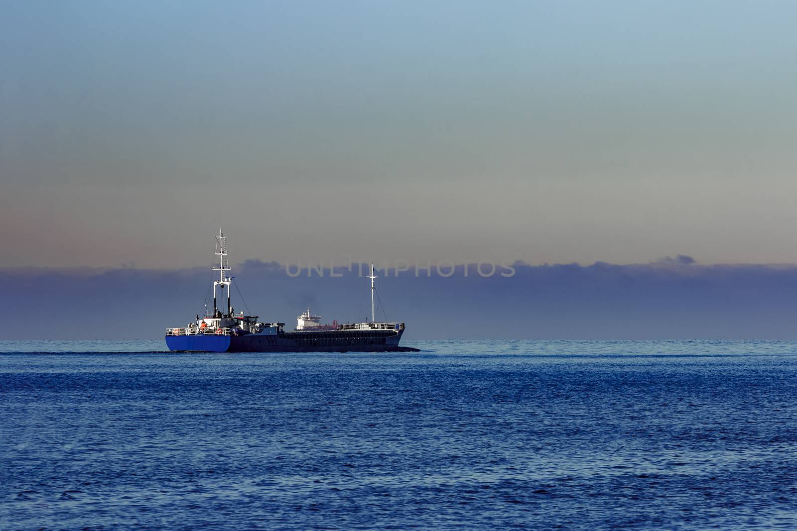 Blue cargo ship leaving Riga and entering Baltic sea