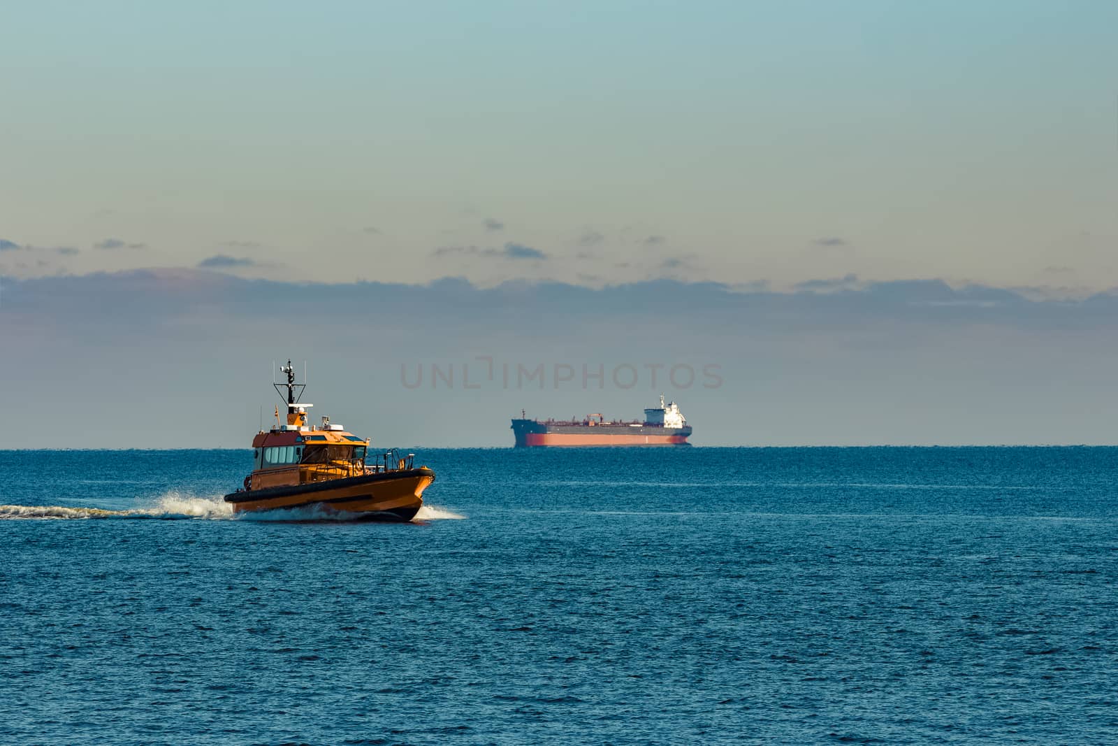 Yellow pilot ship moving at speed from the Baltic sea