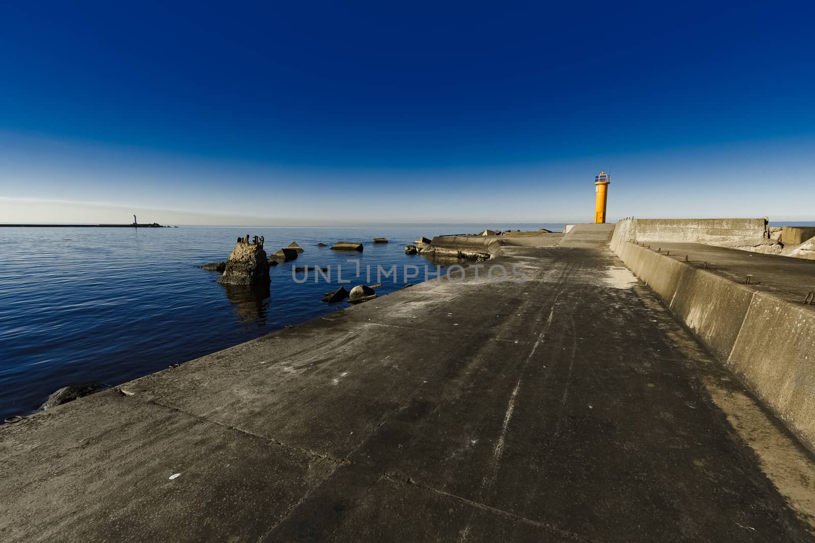 Yellow lighthouse on breakwater dam in Riga, Europe