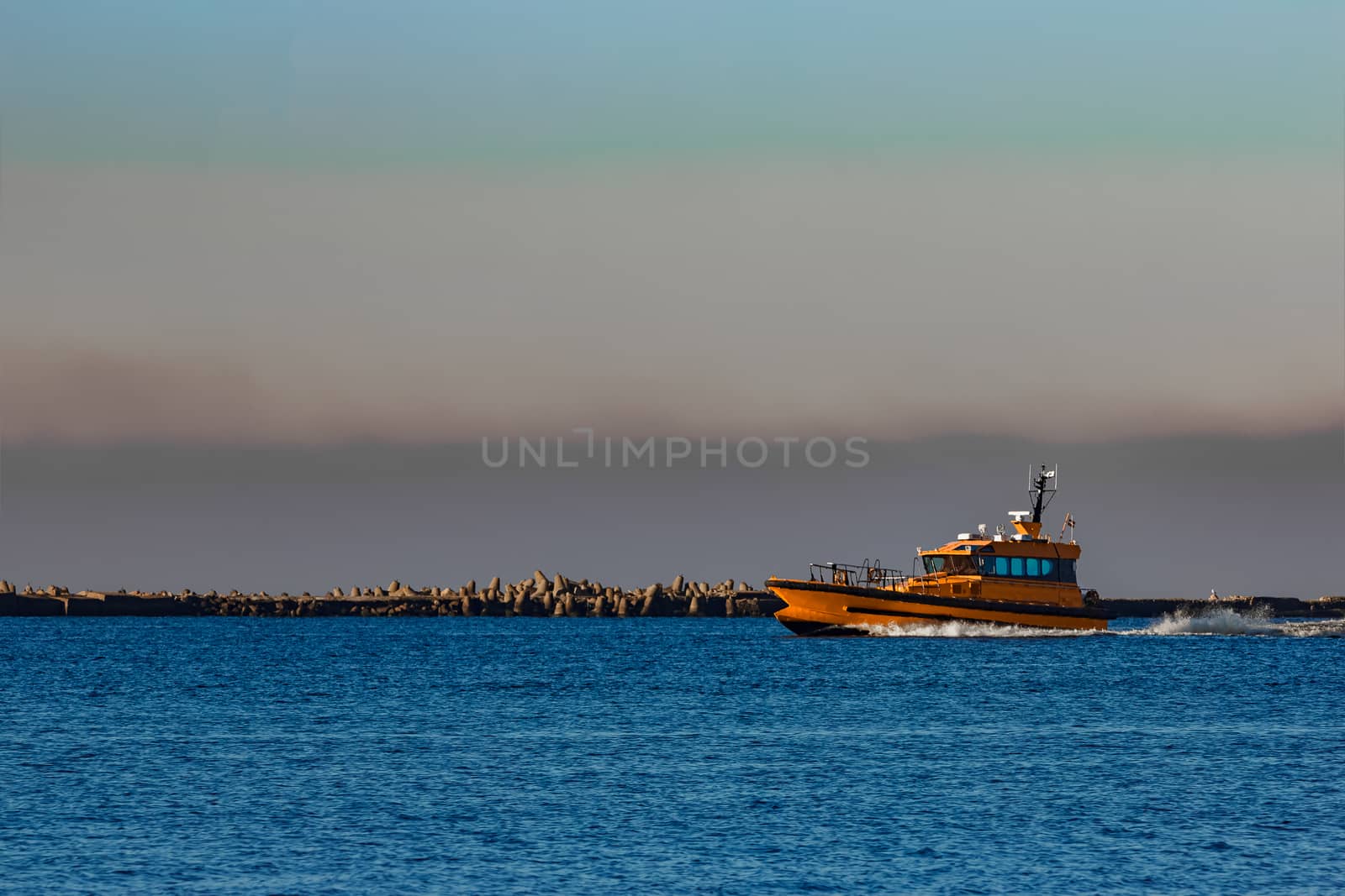 Orange pilot ship sailing from the Baltic sea in Latvia