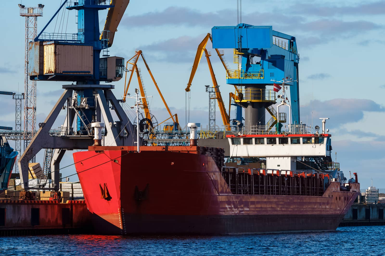 Red cargo ship loading in the port of Riga, Europe