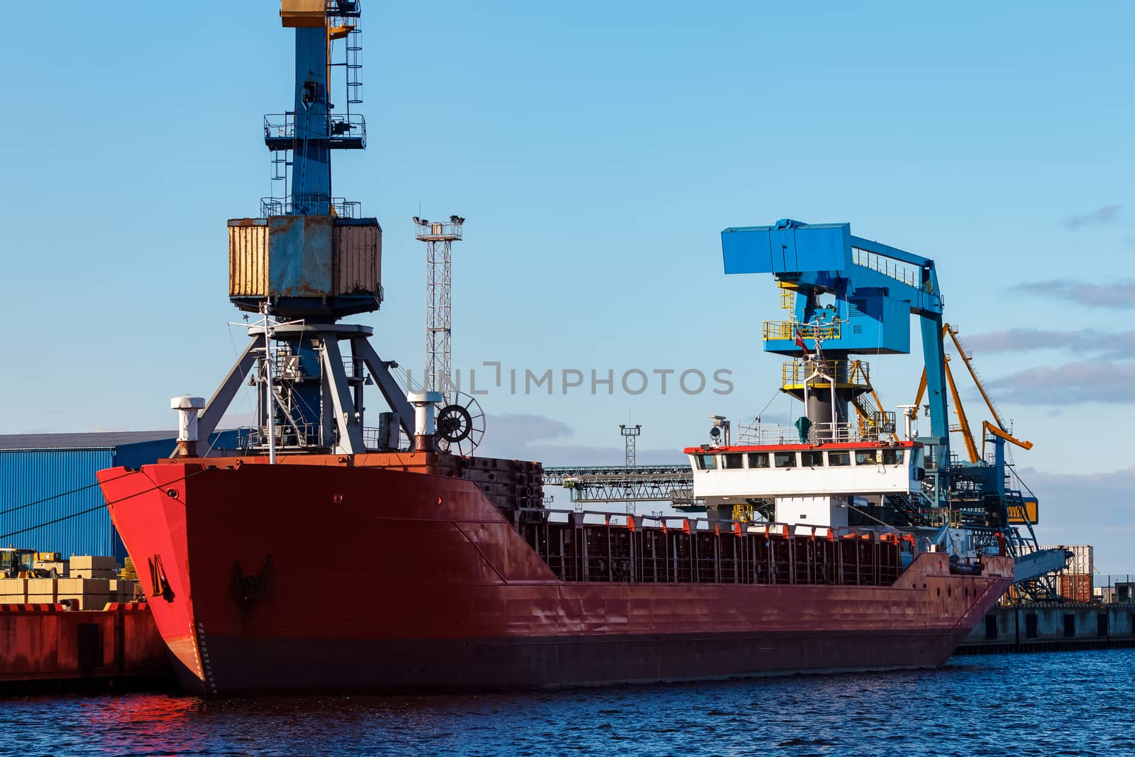 Red cargo ship loading in the port of Riga, Europe