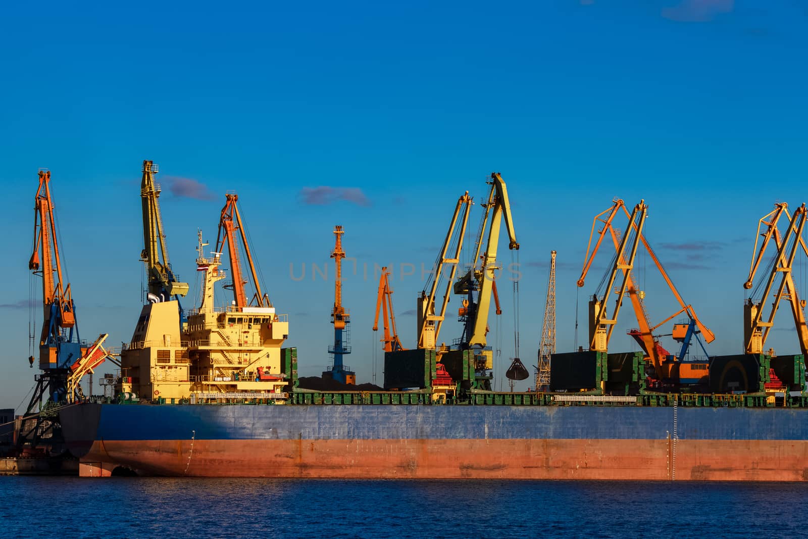 Blue cargo ship loading in the port of Riga, Europe