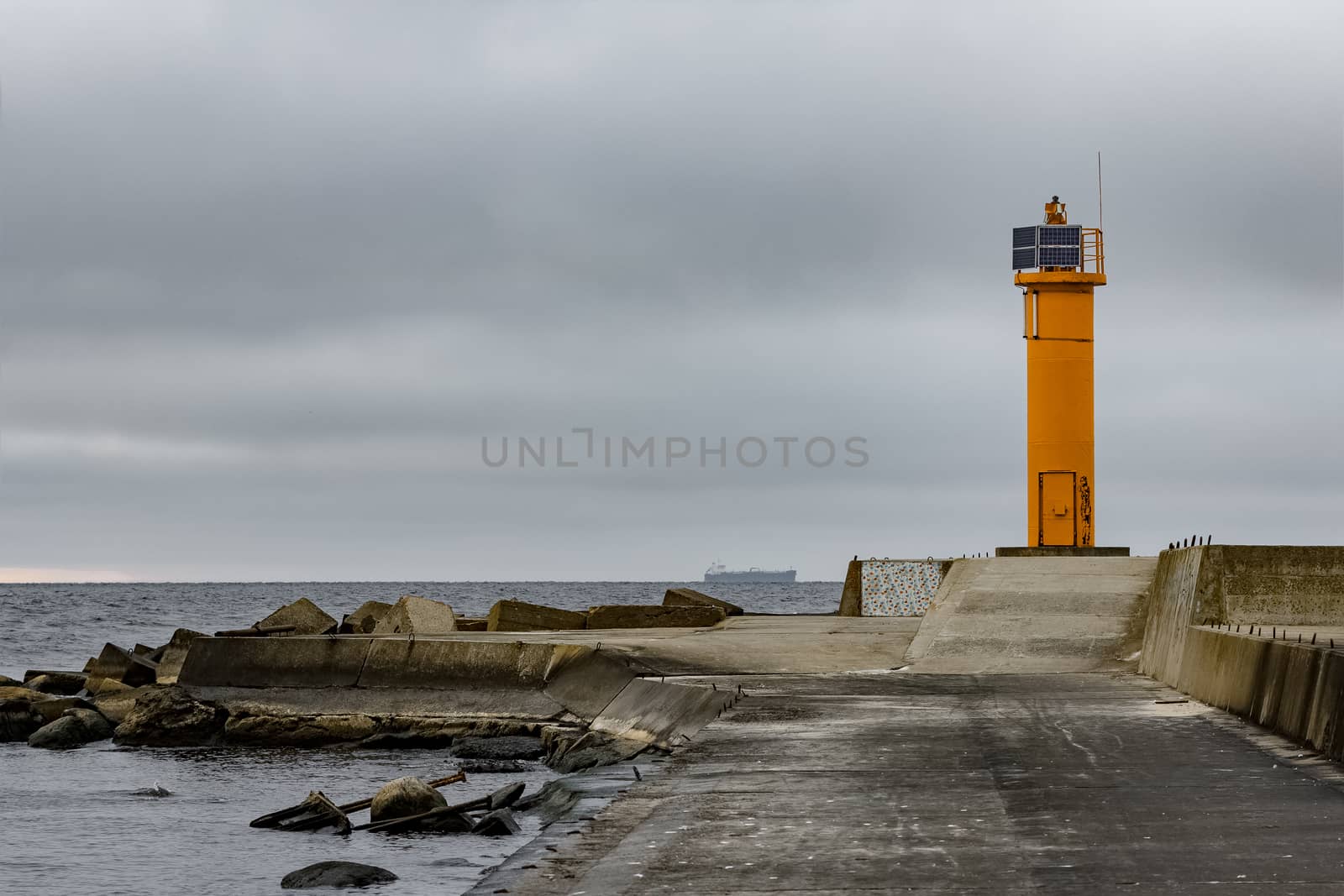 Breakwater dam with yellow lighthouse by sengnsp