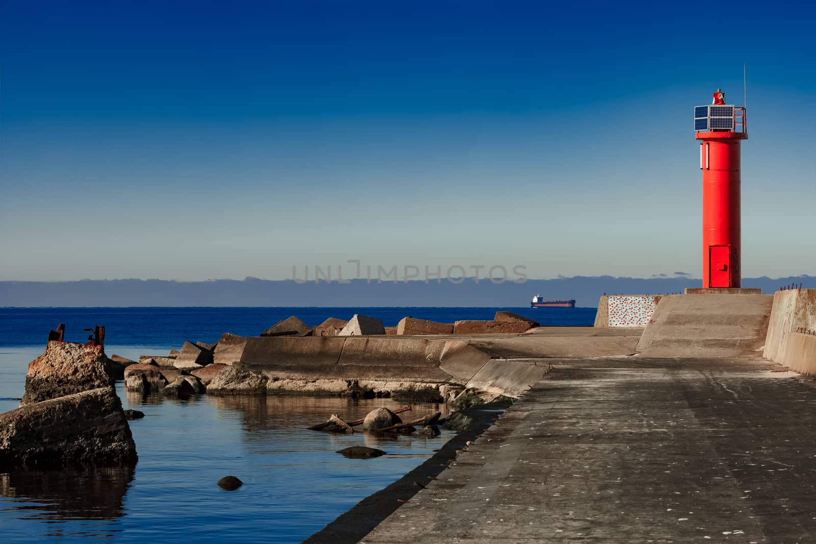 Red lighthouse on breakwater dam by sengnsp