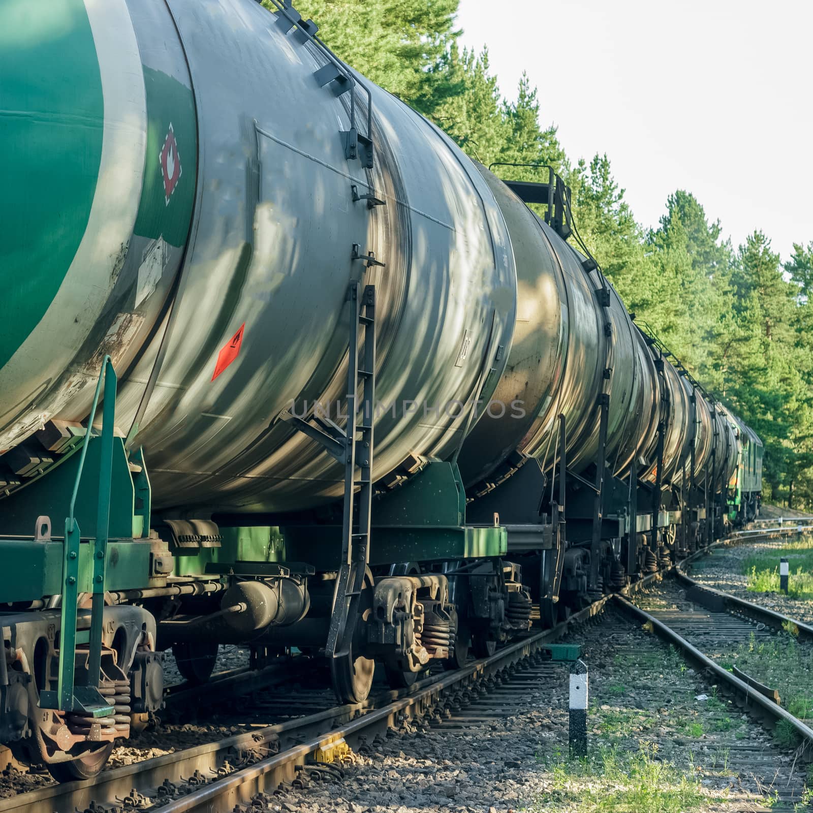 Tank wagons with oil. Freight train in forest