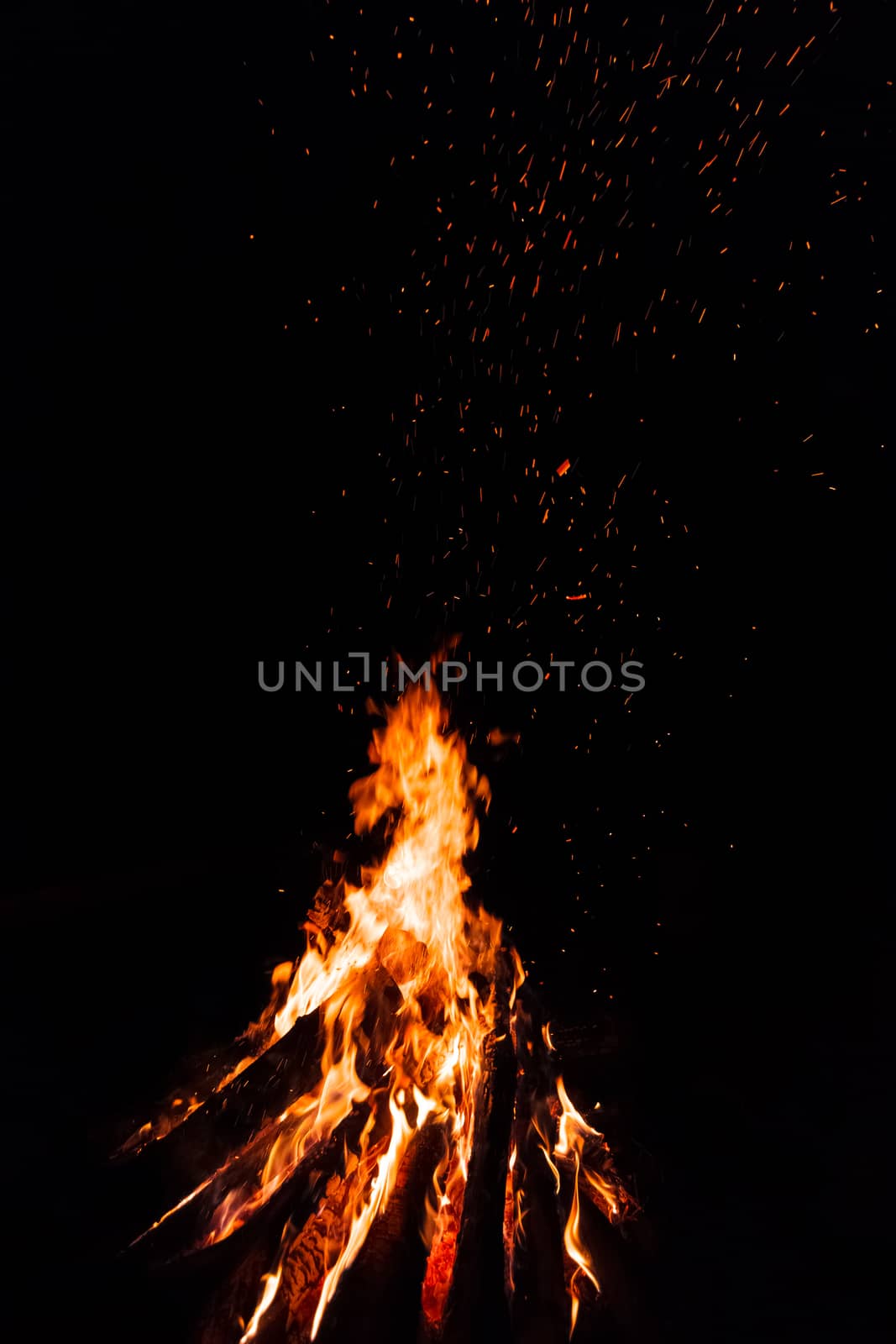 Campfire with flying sparks isolated on black background