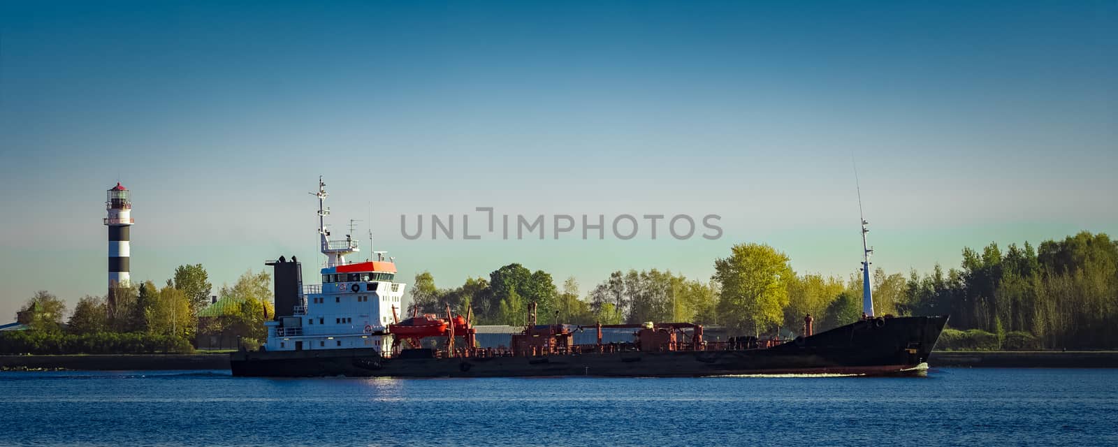 Black cargo oil tanker entering the port of Riga at sunny day