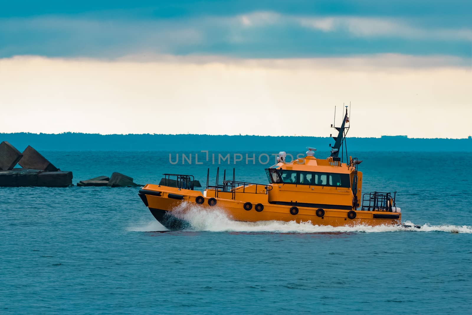 Orange pilot ship moving fast in Baltic sea. Europe