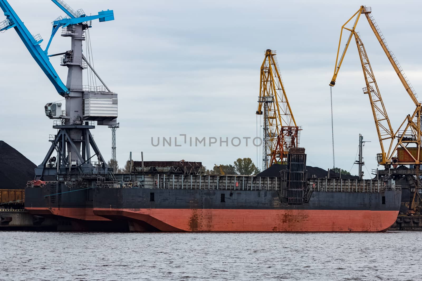 Black barge loading in cargo port of Riga