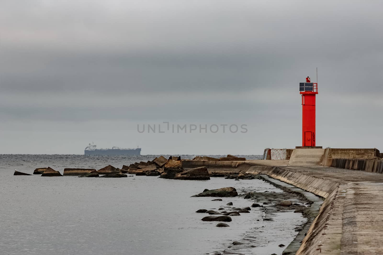 Breakwater dam with red lighthouse by sengnsp