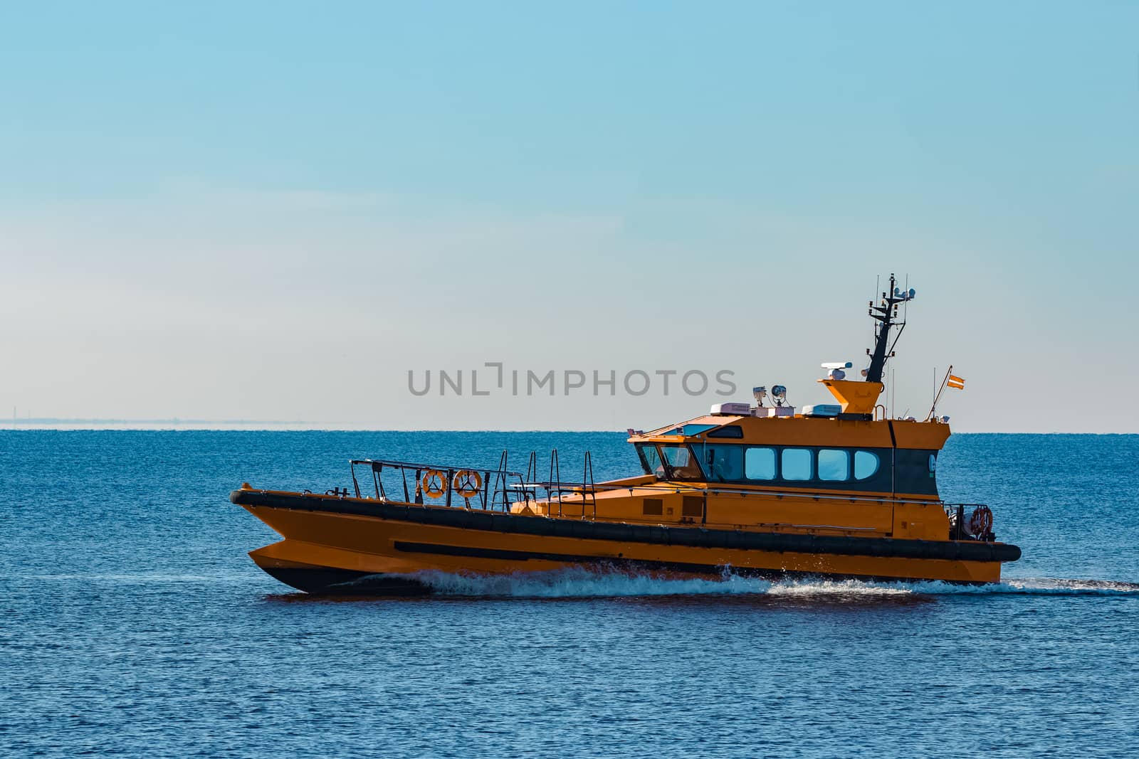 Yellow pilot ship moving at speed from the Baltic sea