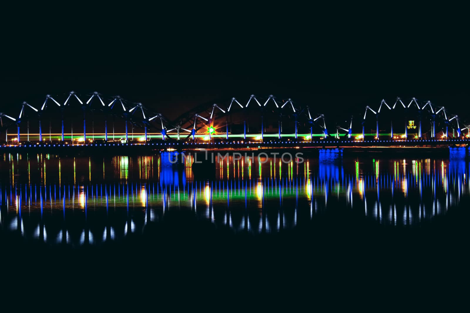 Illuminated railroad bridge in night city, Latvia. Riga bridge