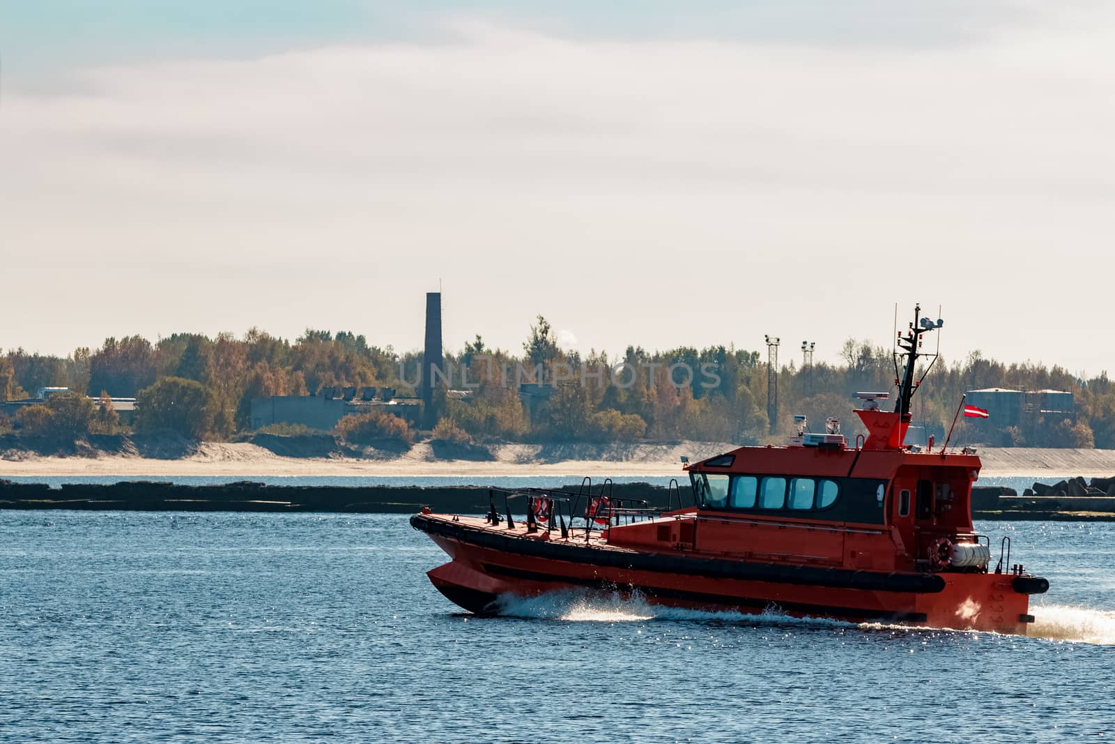 Orange pilot ship moving fast from Baltic sea