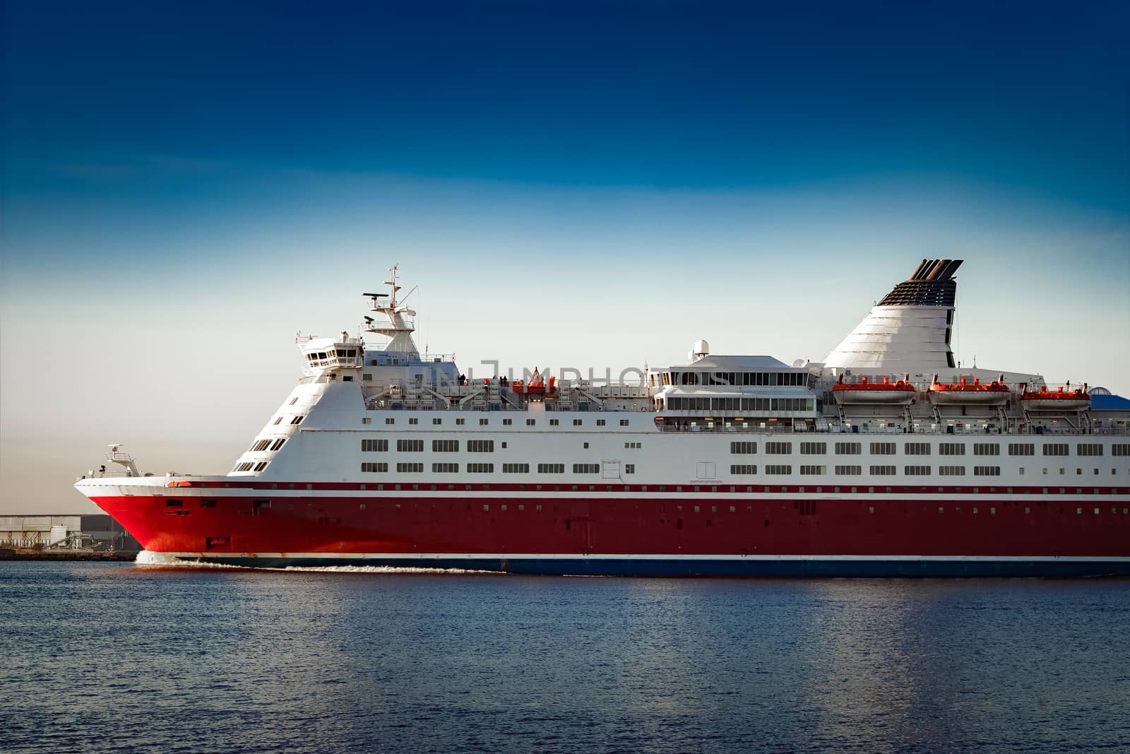 Red cruise liner. Passenger ferry ship sailing in still water