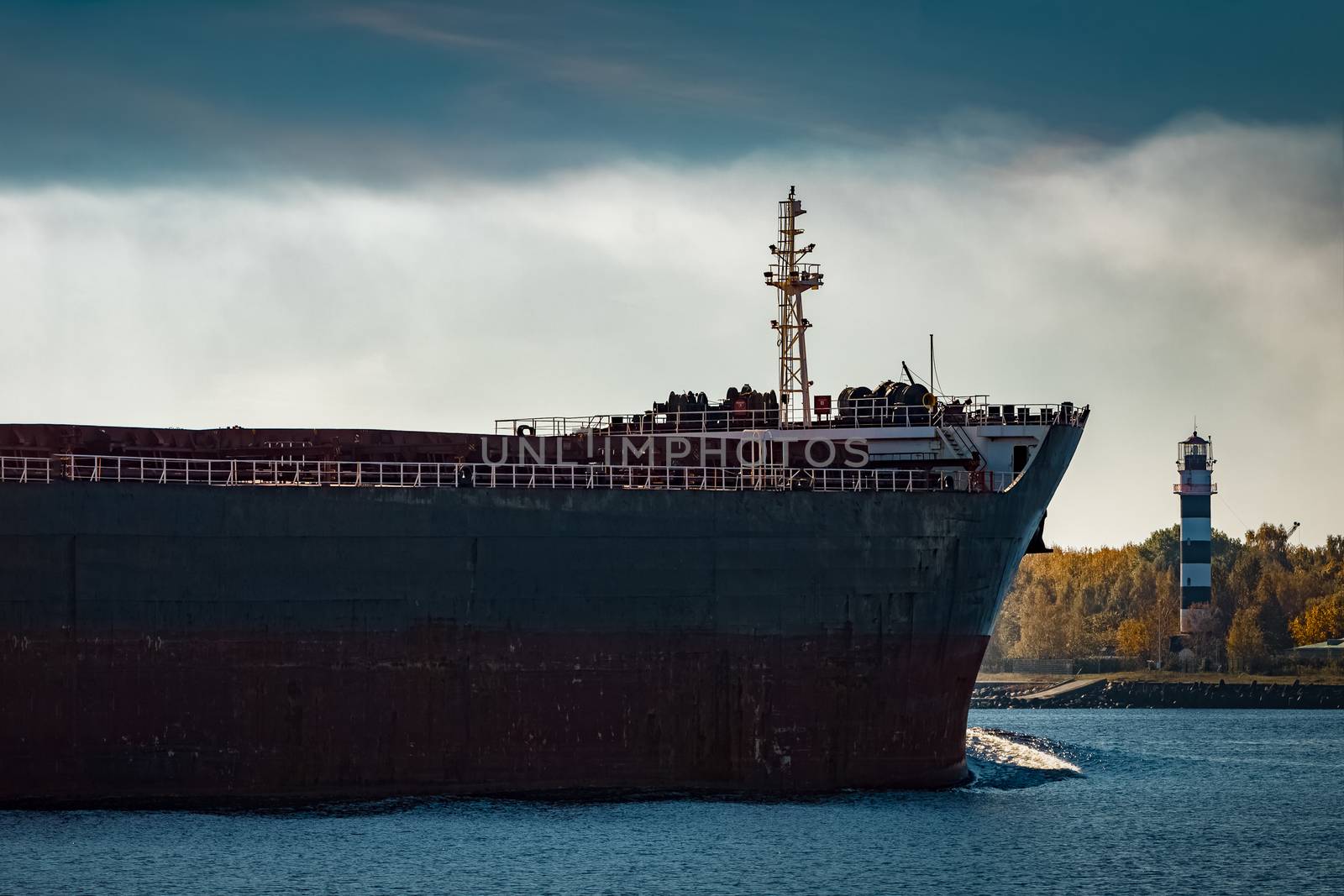 Black cargo ship's bow entering Riga, Europe