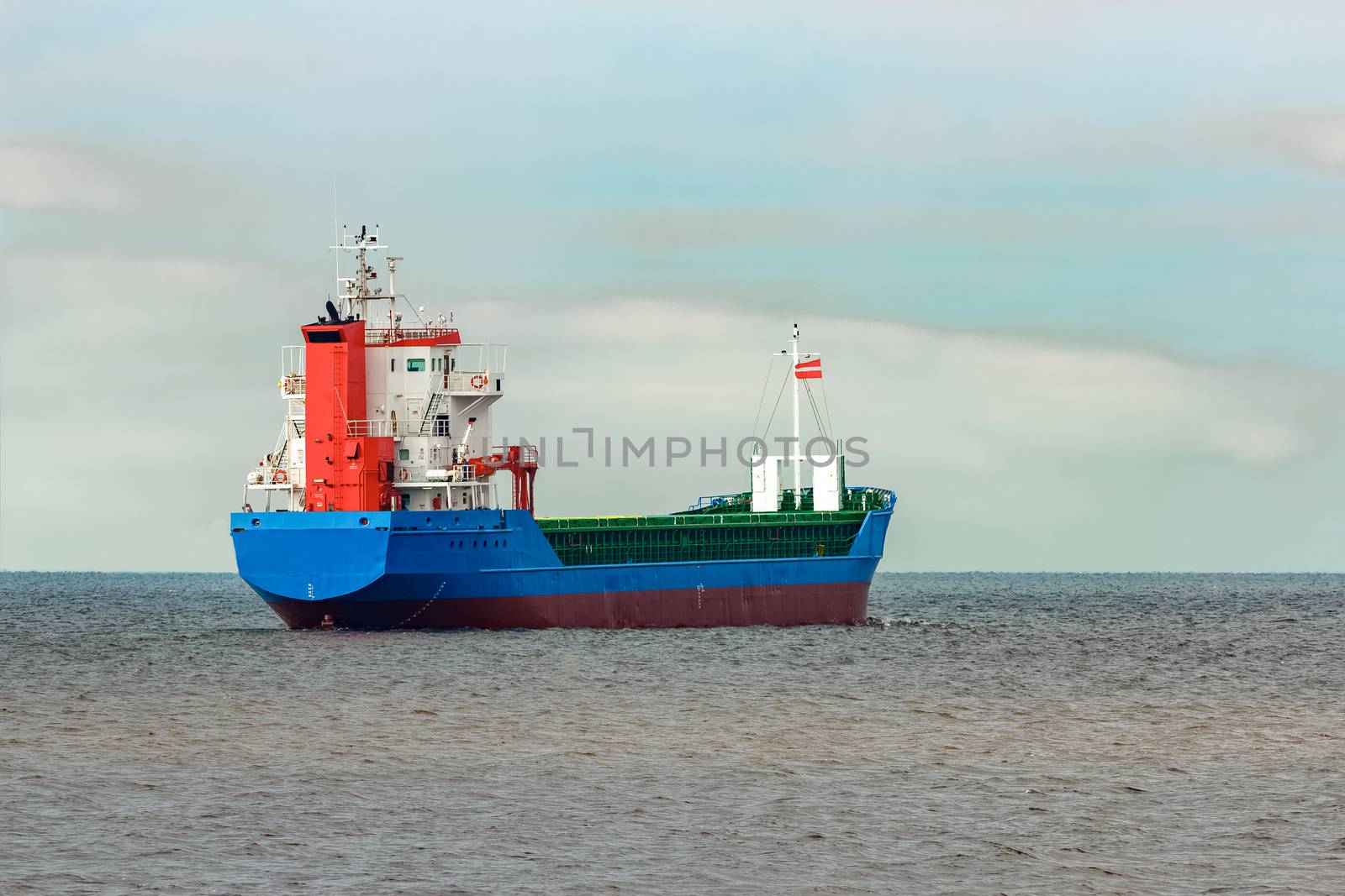 Blue cargo ship entering the Baltic sea. Riga, Europe