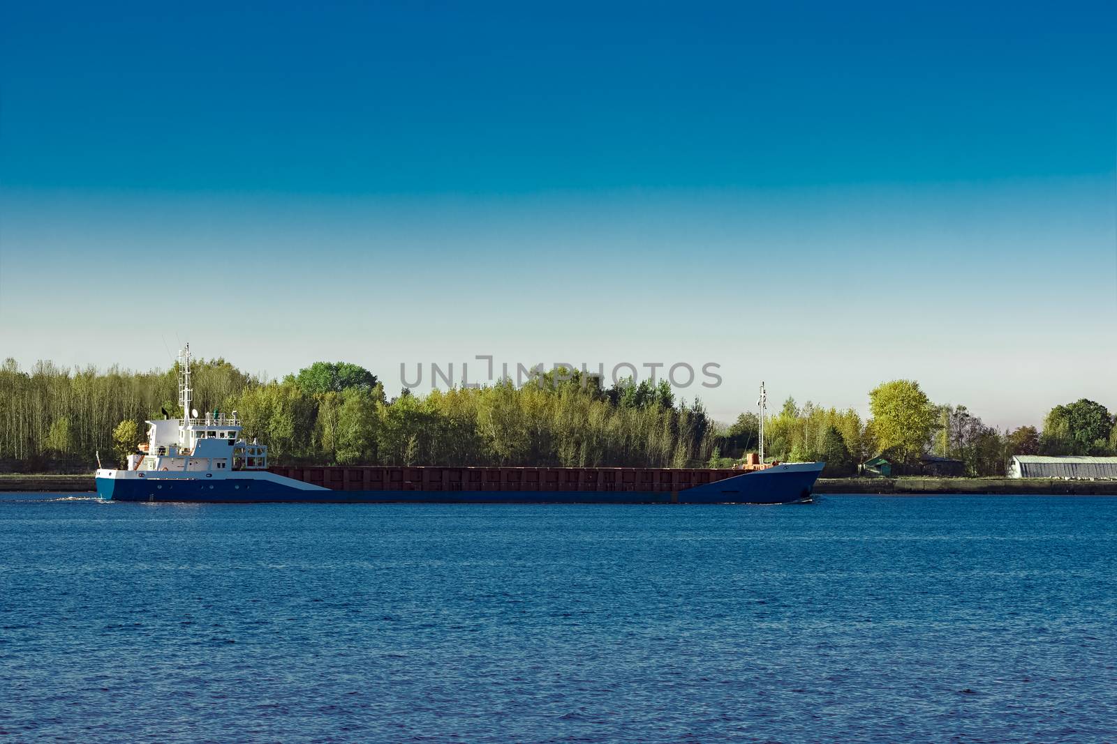 Blue cargo ship leaving Riga and entering Baltic sea