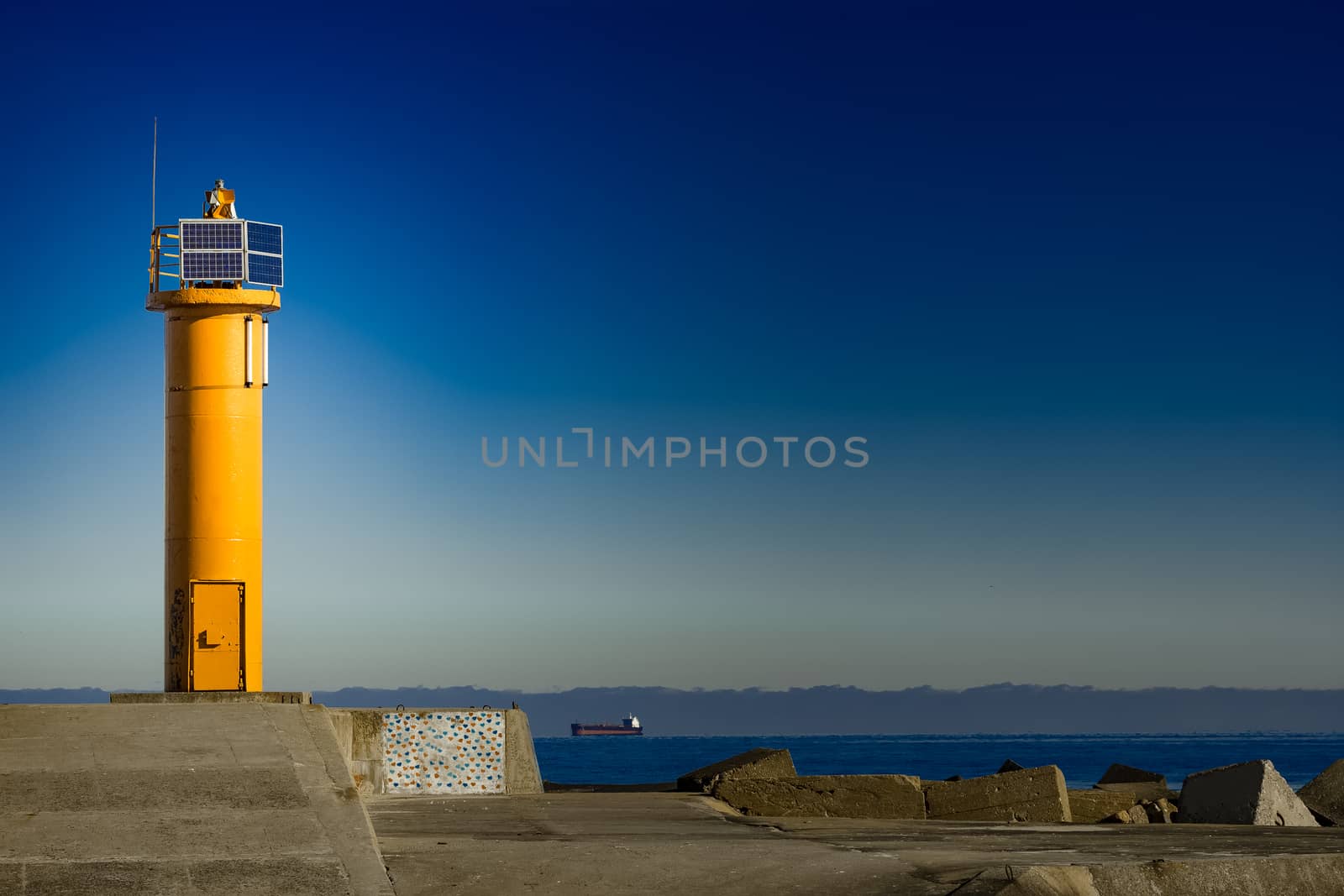 Yellow lighthouse on breakwater dam in Riga, Europe