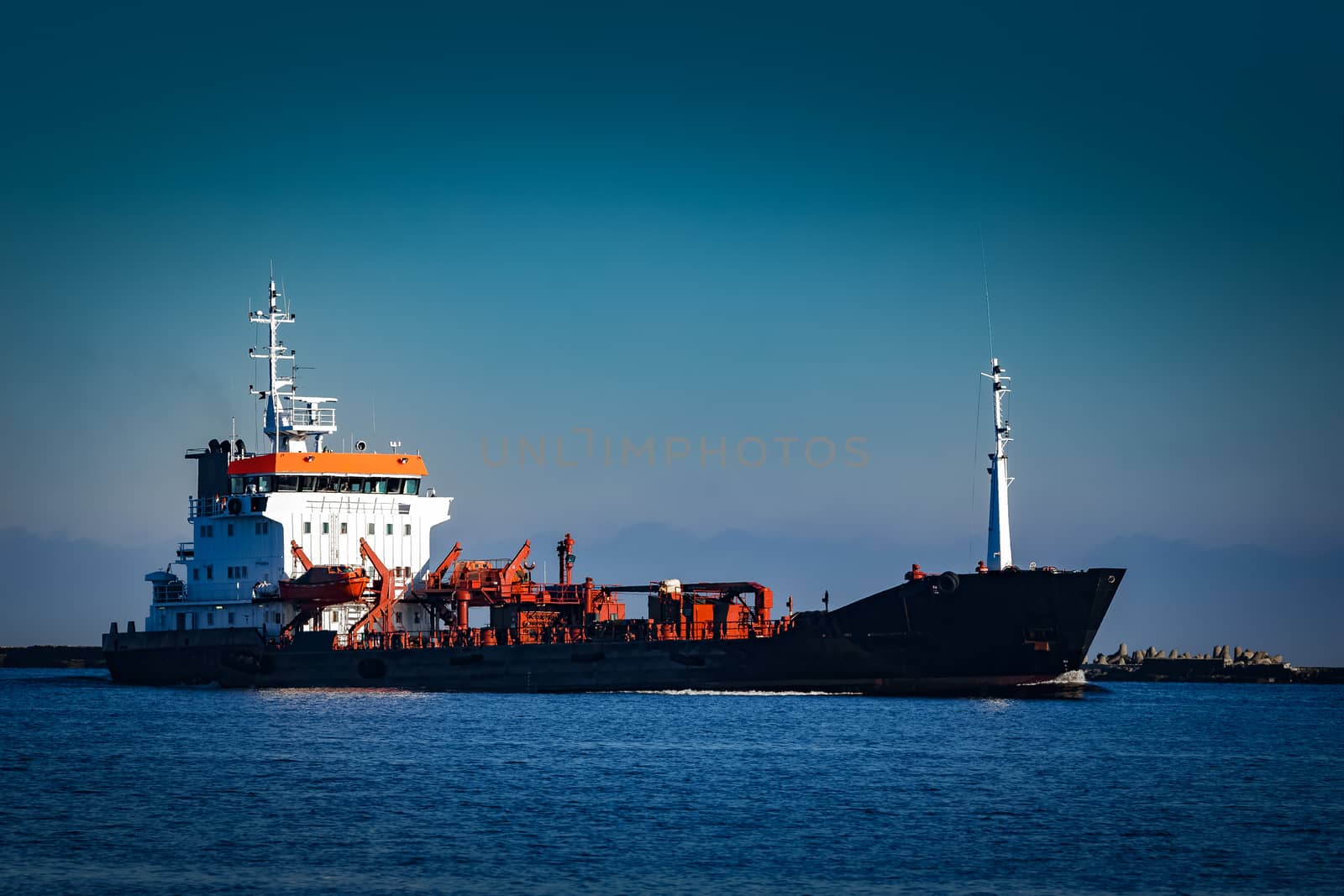 Black cargo oil tanker sailing in still water from Baltic sea