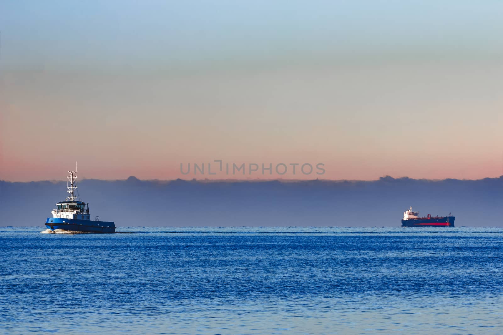Blue small tug ship sailing from the Baltic sea in the morning